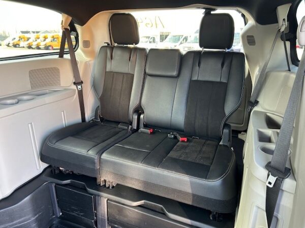 Rear bench seat Three black leather seats in the back of an SUV, each with a headrest and visible seat belts