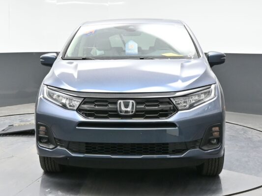 Front view of a silver Honda SUV in a showroom, highlighting the grille and headlights