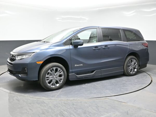 003 Blue BraunAbility-minivan on display, side view with sliding doors and alloy wheels in a bright studio backdrop.