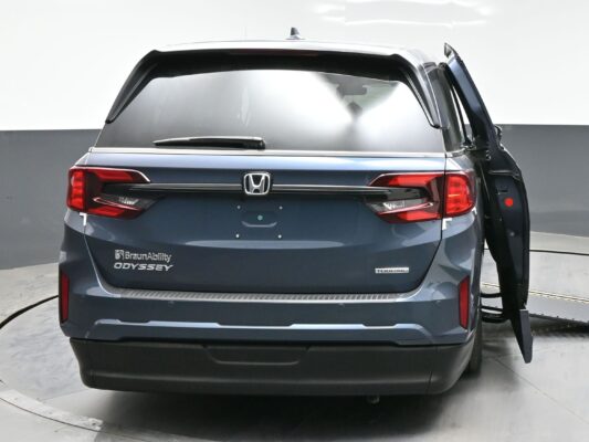 Rear view of a gray Honda Odyssey BraunAbility wheelchair-accessible minivan with the side-entry ramp visible on the right side piece of equipment open.