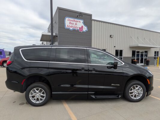 Black BraunAbility wheelchair-accessible van parked in front of a mobility store with a 'Southern Bus & Mobility' sign on the building wall.