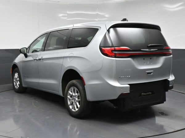 wav-2C4RC1BG3RR138911-4 Silver Chrysler minivan seen from rear-left, showing sliding side door and taillights, in a studio backdrop