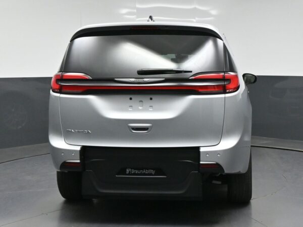 wav-2C4RC1BG3RR138911-5 Rear view of a silver Chrysler Pacifica minivan with BraunAbility branding on the bumper and dark rear window in a studio setting.