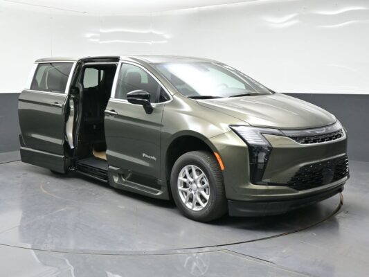 Olive-green wheelchair-accessible minivan with sliding side door open, showing lowered floor and interior seating.