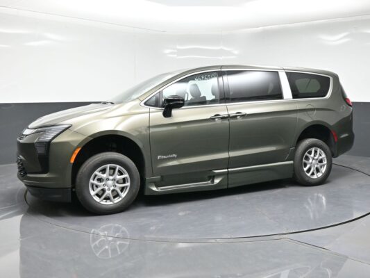 Green-gray BraunAbility wheelchair-accessible minivan shown in a studio, side view with tinted windows and lowered side entry area.