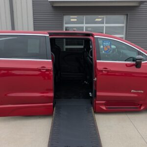 Red BraunAbility wheelchair-accessible van with ramp deployed and side door open, interior visible.