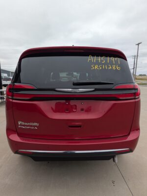 Rear view of a red Chrysler Pacifica BraunAbility minivan with yellow inventory numbers written on the rear window (AH5197, SR511286).